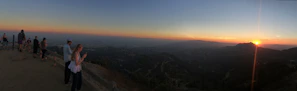 A peaceful sunset view from a scenic overlook, with travelers admiring the horizon.