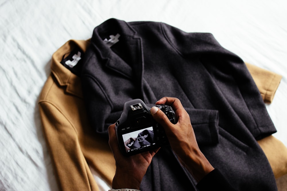台北團體服製作  person taking photo of black and gray coats