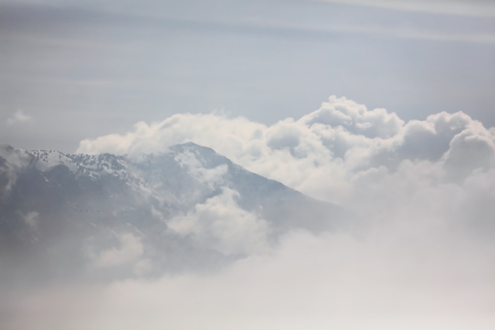 white clouds over snow covered mountain