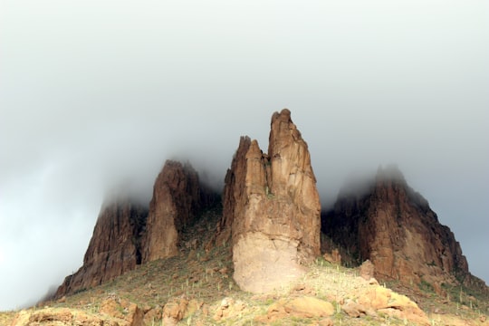 low-angle photography of mountains covered with fog in Gold Canyon United States