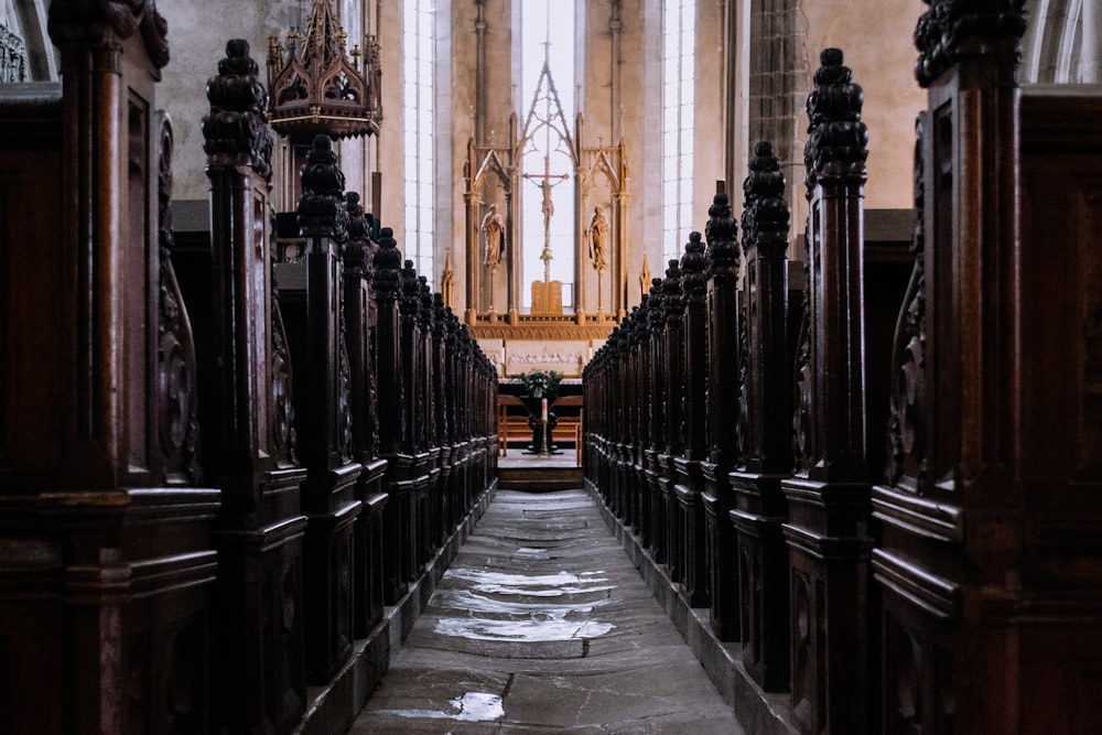 Looking down the aisle between the rows of seating in a church.