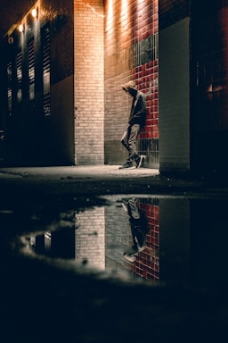 street photography,how to photograph thinking about what’s next.; man learning on concrete wall