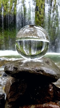clear glass ball on brown rock
