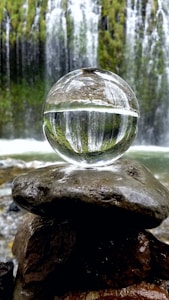 clear glass ball on brown rock