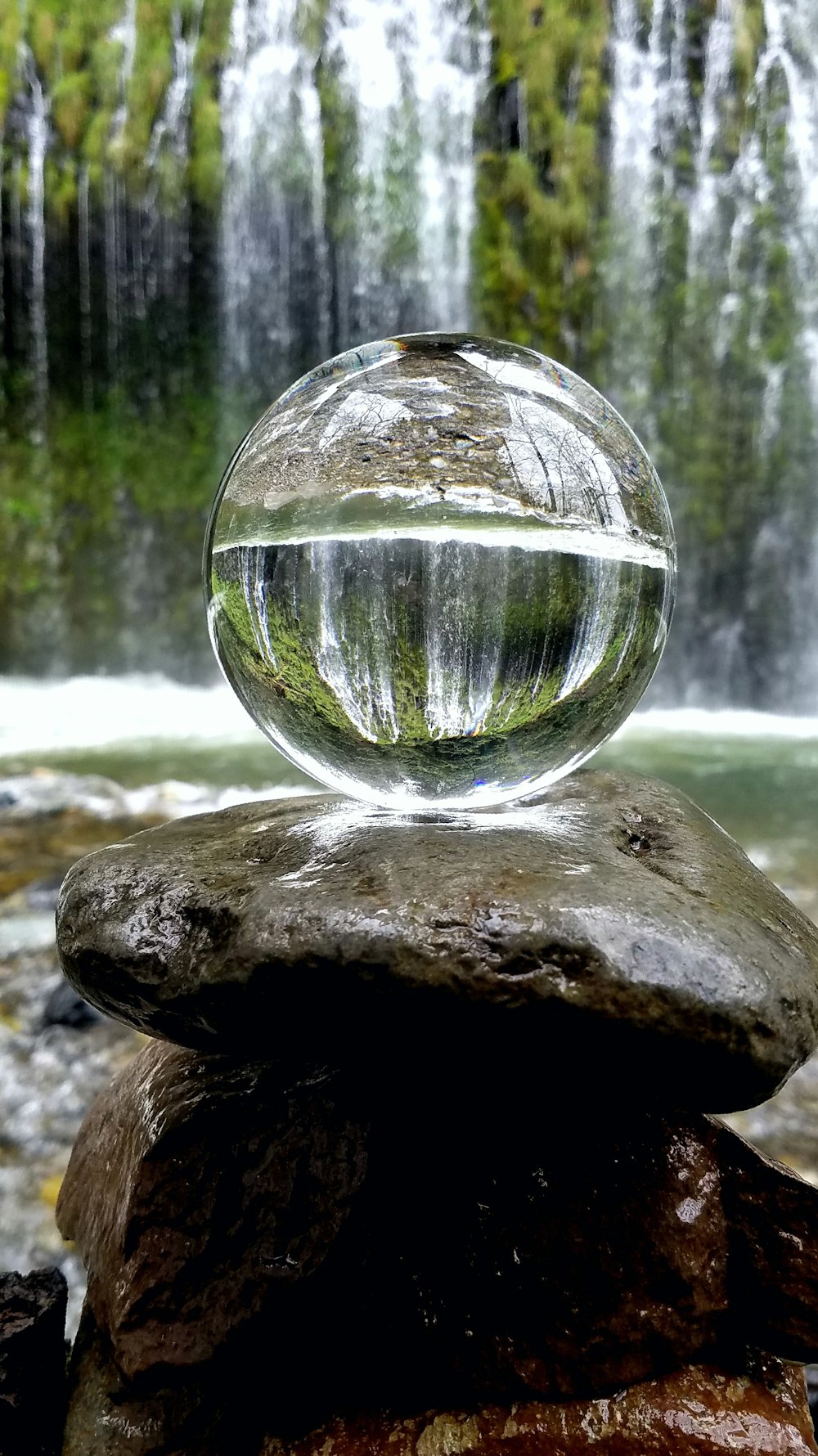 茶色の岩の上の透明なガラス球