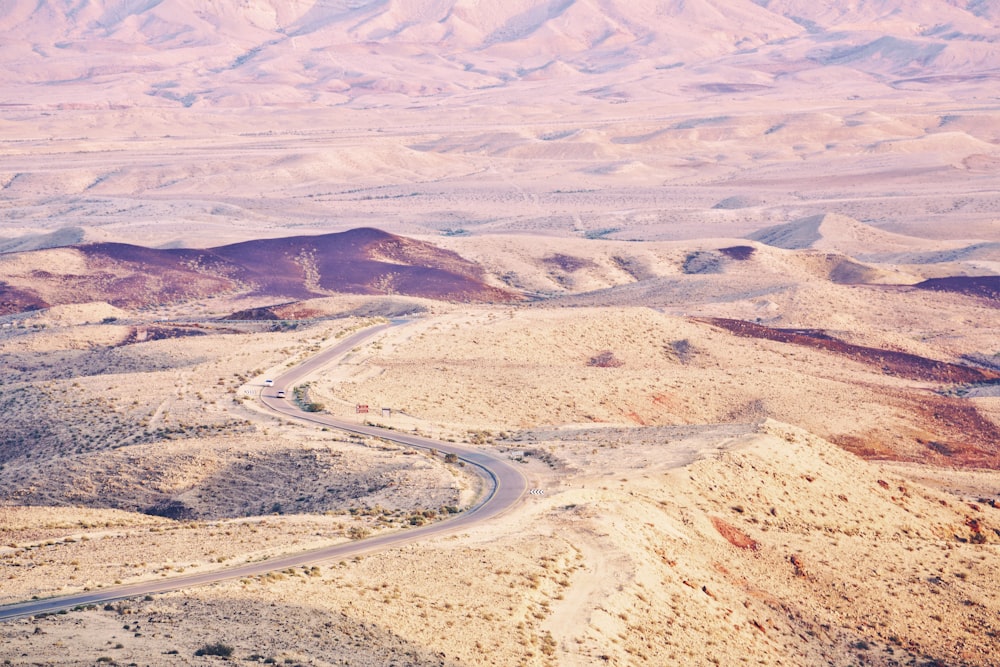 aerial photography of road between desert at daytime