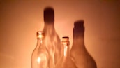 Minimalist display of Trio Aroma’s signature bottles lined up with soft silver lighting highlighting their shapes.