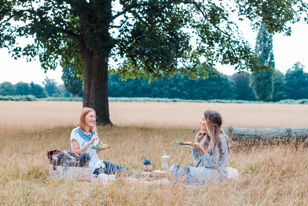 Inconnus assis sur de l’herbe brune