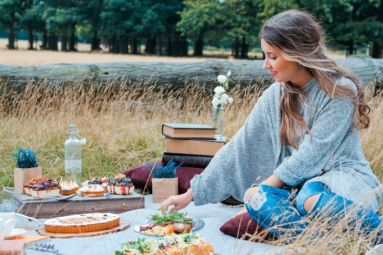 A long outdoor table set with a variety of homemade dishes for a shared meal