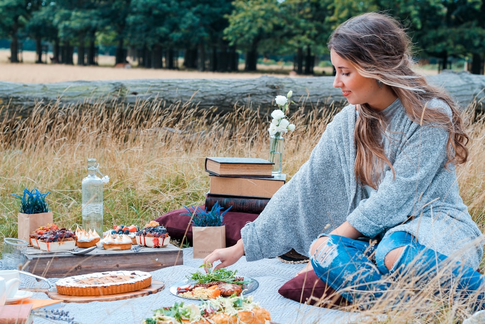 Donna che si siede sulla stuoia da picnic