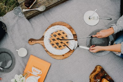 person holding a knife slicing a cake food styling google meet background