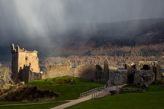 brown castle near green field and brown trees in Loch Ness United Kingdom