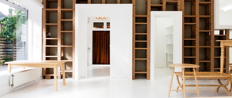 two beige wooden tables in white room