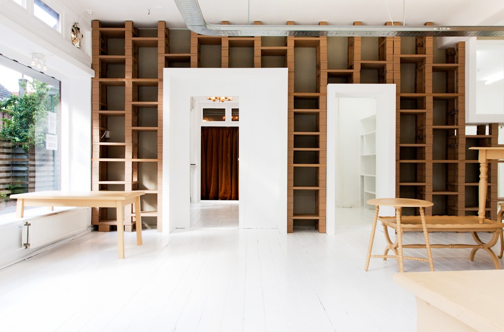 two beige wooden tables in white room