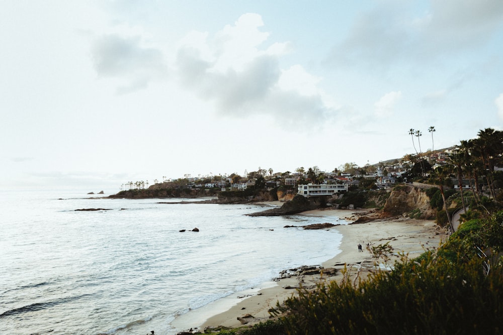 a view of a beach with houses on the shore