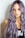 purple haired woman in black top leaning on wall