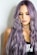 purple haired woman in black top leaning on wall