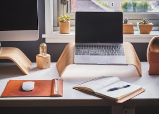 black and silver laptop on brown wooden rack