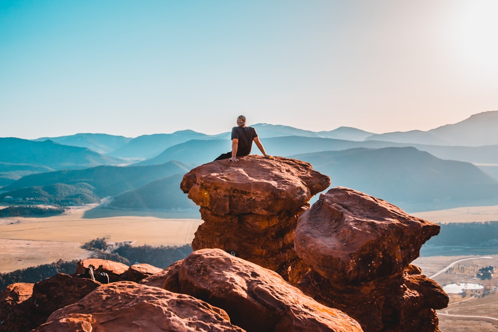 man sitting on rock formation