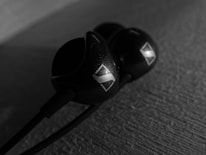 A close-up of earbuds with adaptive sound technology.