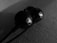 Close-up of sleek black earbuds resting on a soft neutral fabric background.