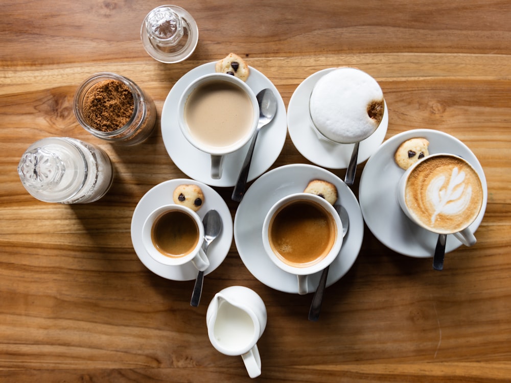 Flatlay-Fotografie von fünf Latte-Bechern