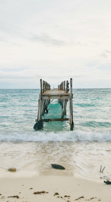 An old wooden pier extending into a tranquil bay.