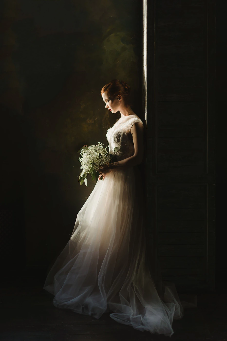Bride holding a bouquet of ivory and blush flowers