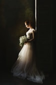 woman wearing wedding gown white holding bouquet