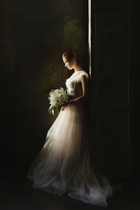 woman wearing wedding gown white holding bouquet