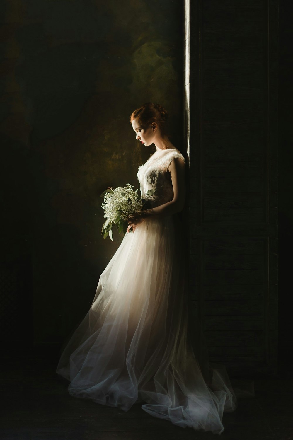 Frau trägt Hochzeitskleid weiß mit Blumenstrauß