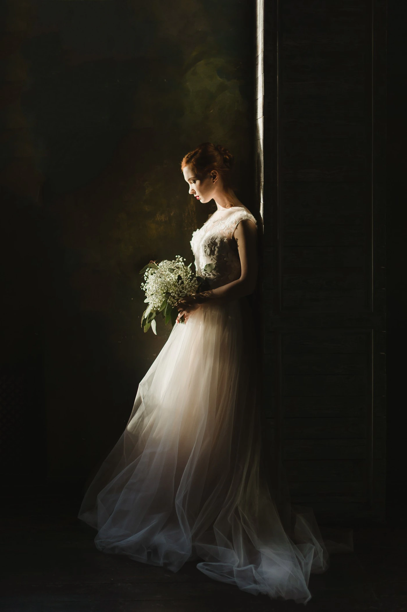 Woman in a white wedding gown holding a bouquet in a deliberately styled and composed fashion-forward editorial pose
