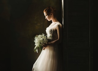 woman wearing wedding gown white holding bouquet