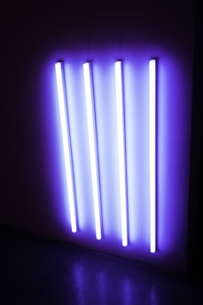 Close-up of an ultraviolet air sterilizer in operation, glowing softly in a modern office setting.
