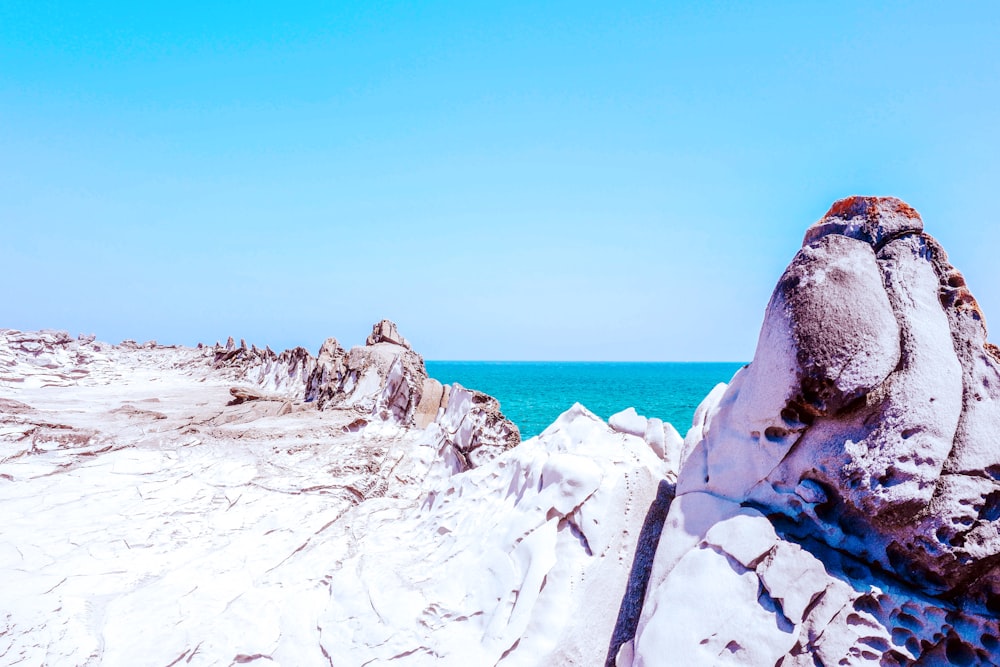 white and gray stone formation near sea at daytime