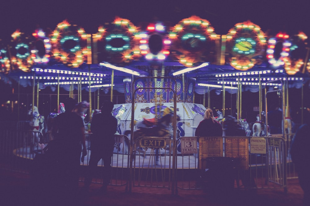 people standing besides Merry-Go-Round during nighttime