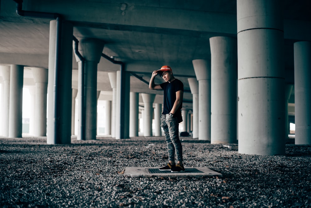 uomo in piedi sul pavimento di cemento grigio