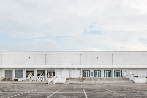Exterior shot of a warehouse with clear signage and ample parking space.