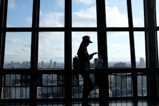 A delivery person holding a package with a city skyline in the background.