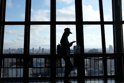 A delivery person holding a package with a city skyline in the background.