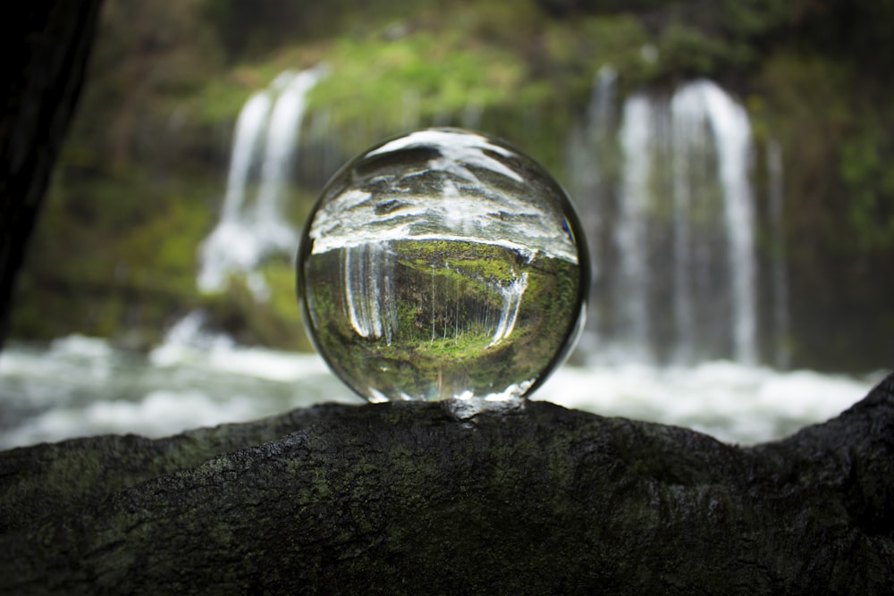 Wasser, das aus klarer Glaskugel fällt