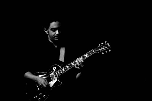 Close-up of a musician passionately playing an electric guitar in a cozy studio setting.