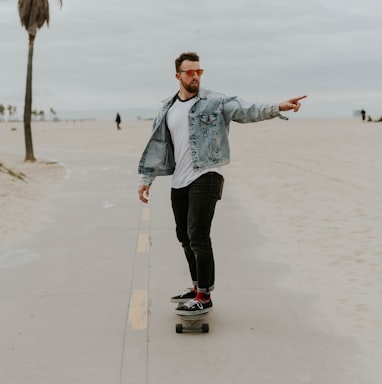 men's washed denim jacket riding a skateboard