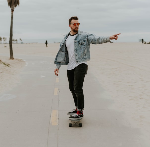 men's washed denim jacket riding a skateboard