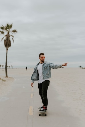 men's washed denim jacket riding a skateboard