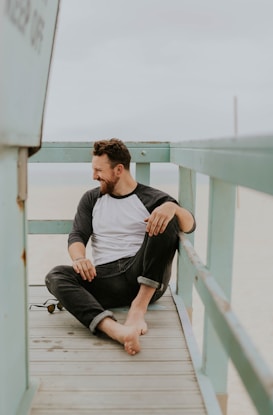 man smiling while sitting on floor during daytime