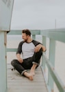 man smiling while sitting on floor during daytime