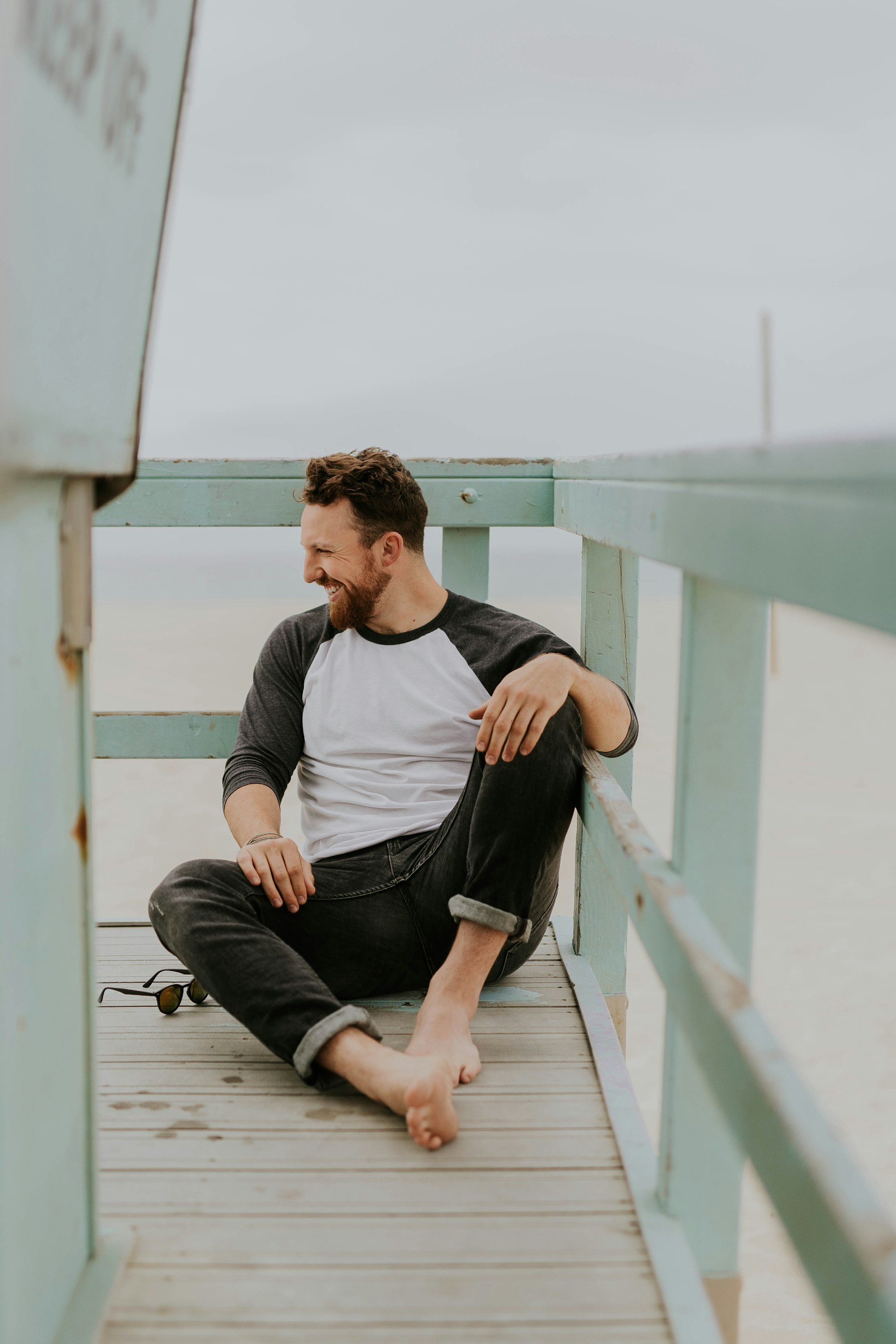 man smiling while sitting on floor during daytime