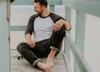 man smiling while sitting on floor during daytime