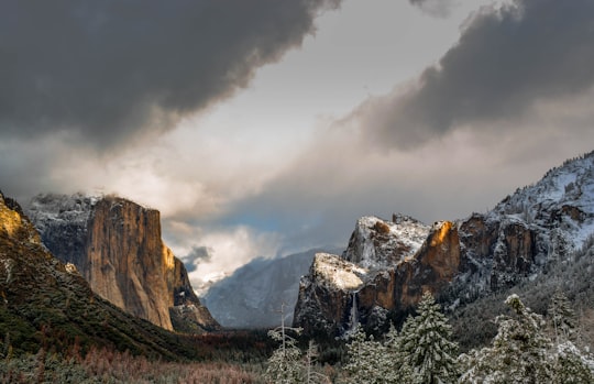 mountain covered with snow under black clouds during daytime in Yosemite National Park United States